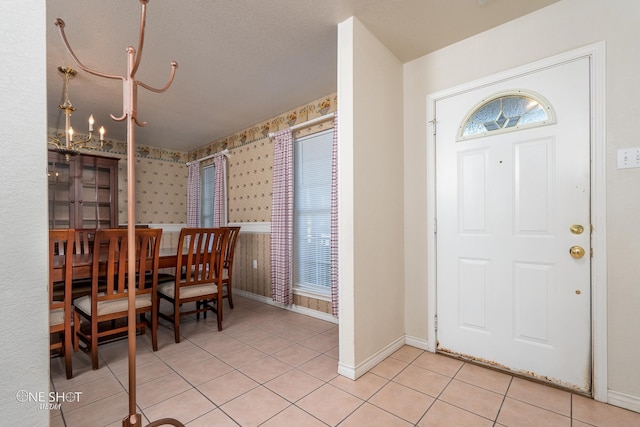 tiled entryway with an inviting chandelier