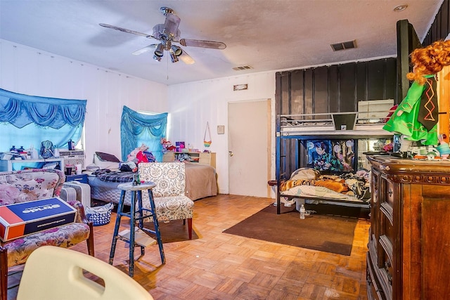 bedroom with ceiling fan, light parquet flooring, and a textured ceiling