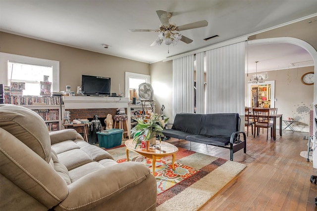 living room with light hardwood / wood-style floors, ornamental molding, and ceiling fan