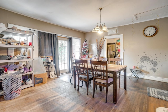 dining room with an inviting chandelier, ornamental molding, and hardwood / wood-style flooring