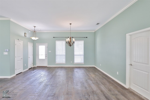 spare room featuring crown molding, a chandelier, and wood-type flooring