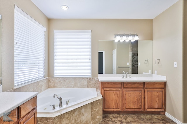 bathroom with a relaxing tiled tub, vanity, and tile patterned flooring