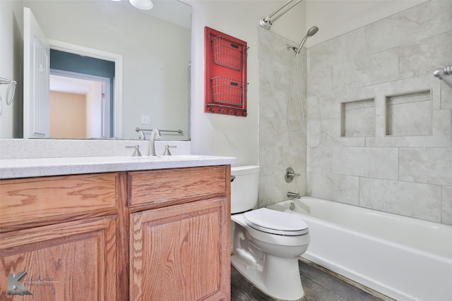 full bathroom featuring vanity, tiled shower / bath combo, and toilet