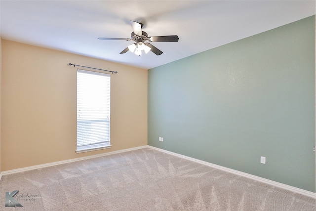 carpeted spare room featuring a wealth of natural light and ceiling fan