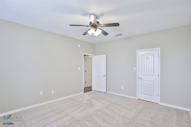 empty room featuring ceiling fan and light colored carpet