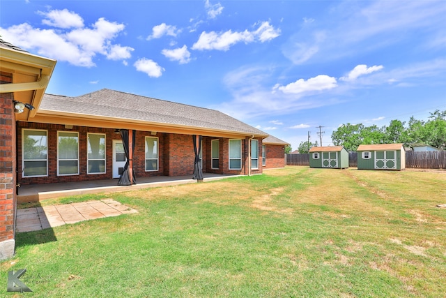 back of property featuring a storage shed, a patio, and a yard