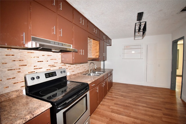 kitchen with electric range, sink, light hardwood / wood-style flooring, a textured ceiling, and backsplash