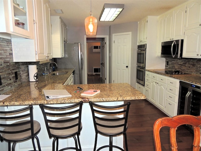 kitchen with sink, beverage cooler, stainless steel appliances, kitchen peninsula, and decorative backsplash