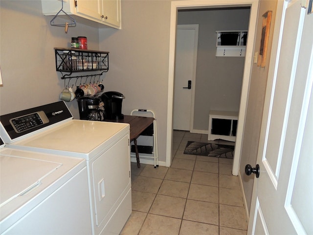 clothes washing area featuring cabinets, light tile patterned floors, and separate washer and dryer