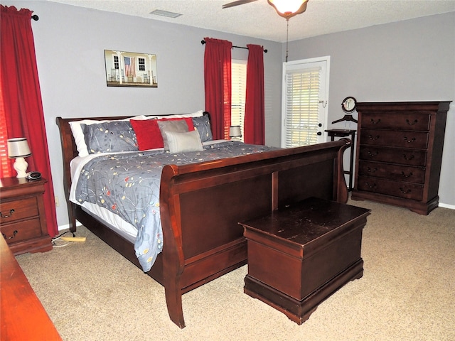 carpeted bedroom featuring a textured ceiling and ceiling fan