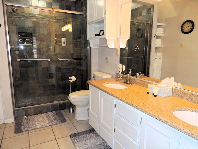 bathroom with tile patterned flooring, vanity, a shower with door, and toilet