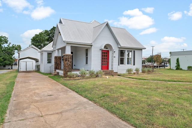 view of front of house featuring a garage, a front lawn, and an outbuilding