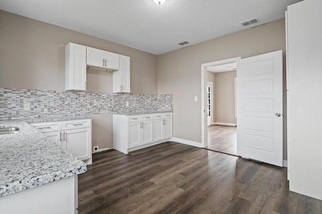 kitchen with white cabinetry, dark hardwood / wood-style flooring, and backsplash