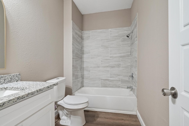 full bathroom featuring vanity, tiled shower / bath combo, toilet, and hardwood / wood-style floors