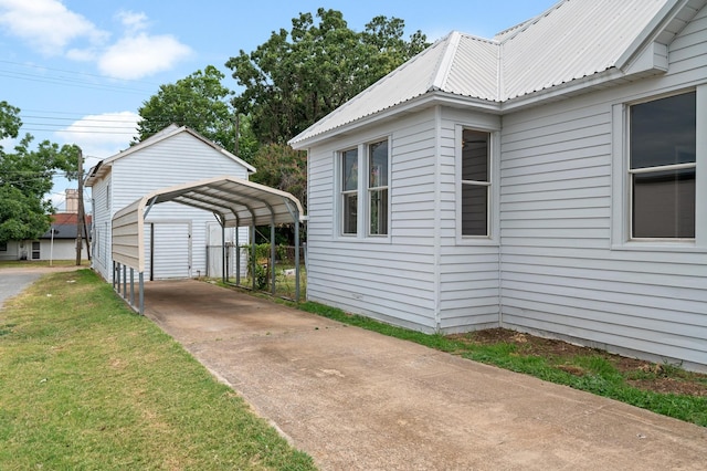 view of side of property with a carport and a lawn