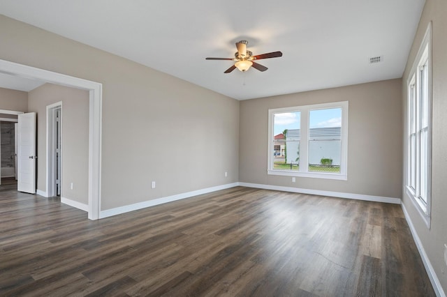 empty room with ceiling fan and dark wood-type flooring