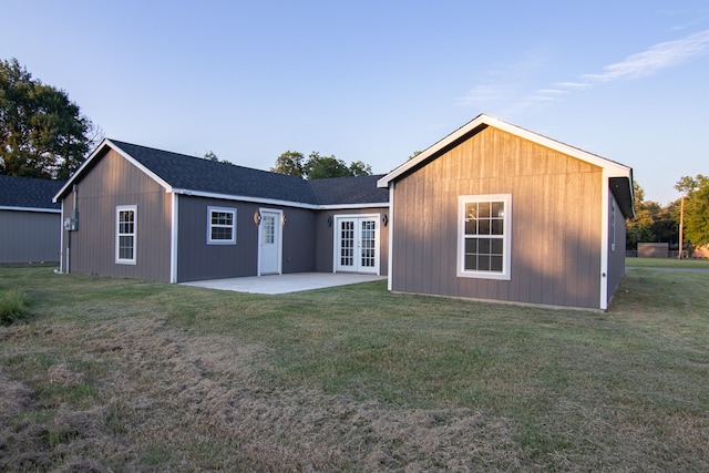 rear view of house featuring french doors, a patio area, and a lawn