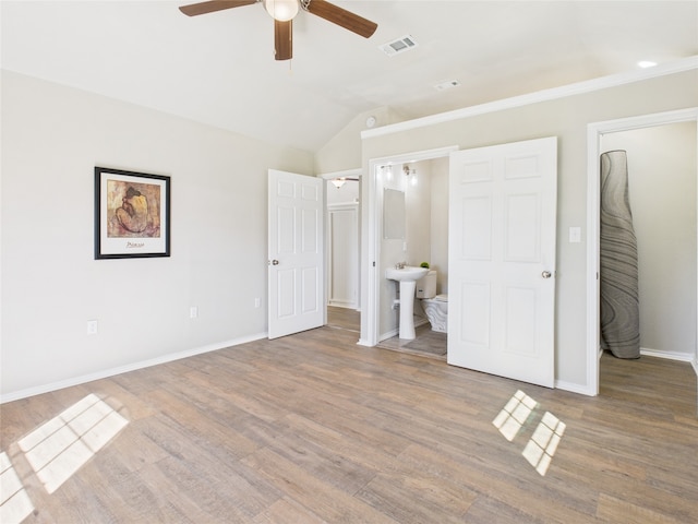 unfurnished bedroom featuring visible vents, ceiling fan, baseboards, lofted ceiling, and wood finished floors