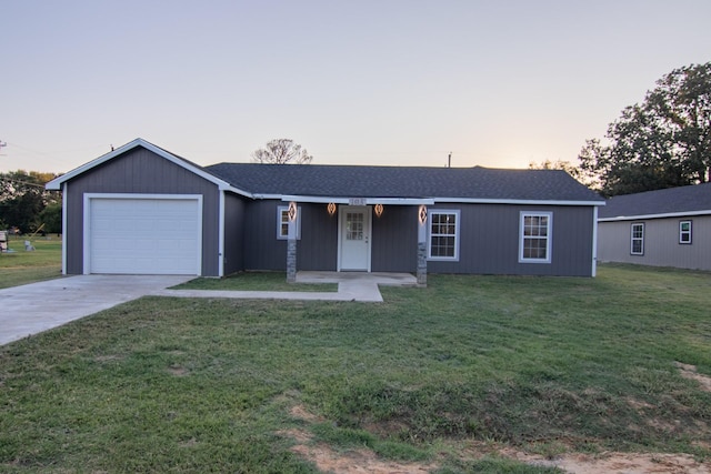 ranch-style house with a front yard, an attached garage, and driveway