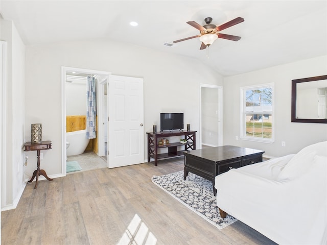 living room featuring vaulted ceiling, a ceiling fan, visible vents, and light wood finished floors