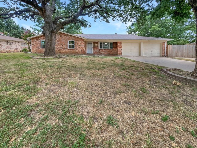 ranch-style home featuring a garage and a front lawn