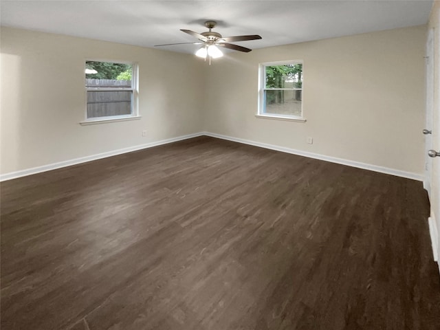 spare room featuring dark hardwood / wood-style flooring, a wealth of natural light, and ceiling fan