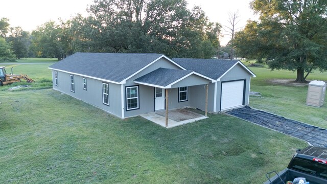 ranch-style house with a garage and a front lawn