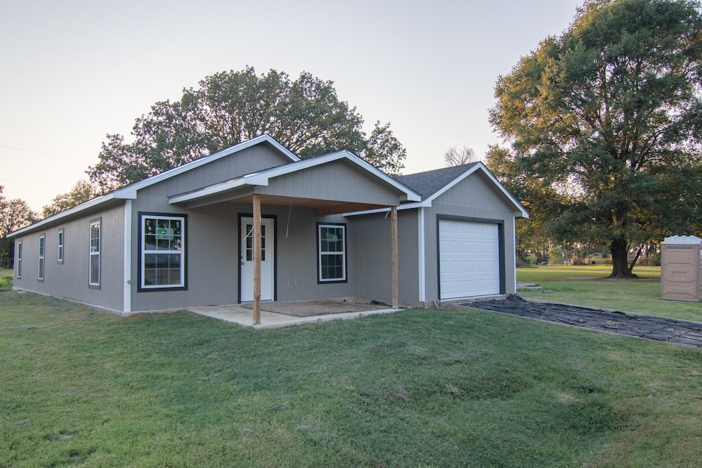 single story home with a garage, driveway, and a front yard