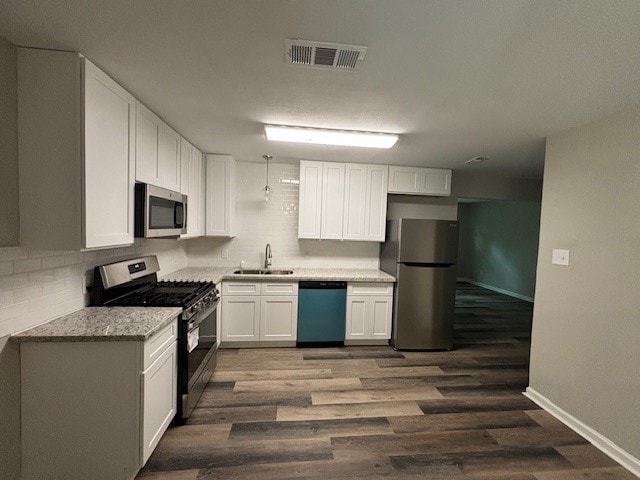 kitchen featuring sink, dark wood-type flooring, stainless steel appliances, and white cabinetry