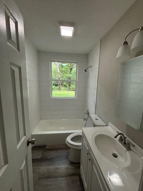 bathroom with toilet, shower / bath combination, wood finished floors, and vanity