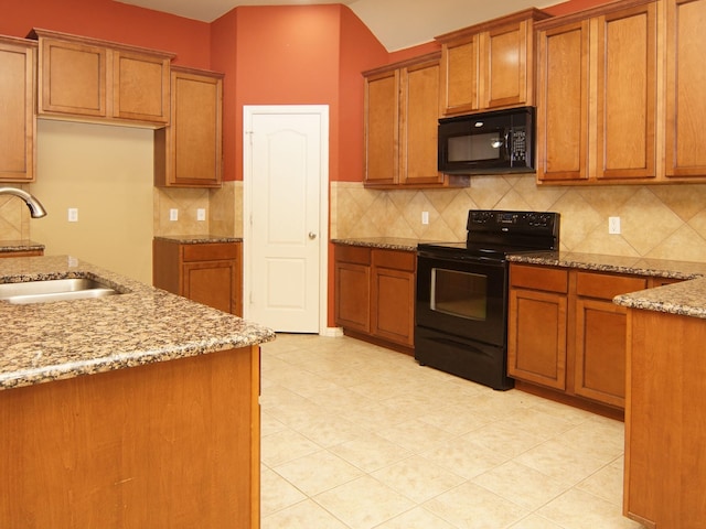 kitchen with black appliances, sink, light stone counters, and decorative backsplash