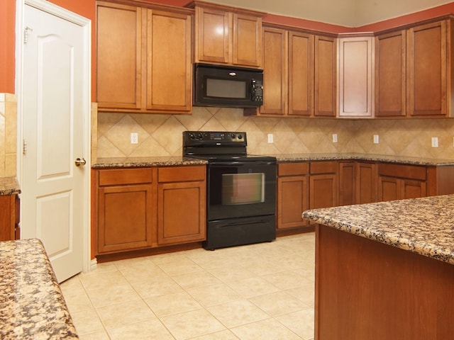 kitchen with backsplash, light stone countertops, light tile patterned floors, and black appliances