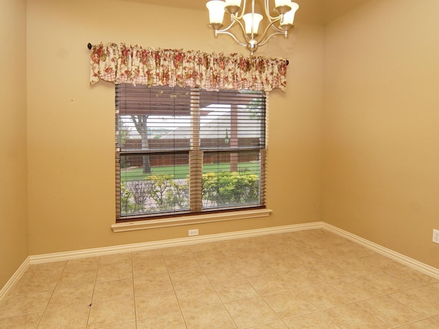 tiled spare room with a notable chandelier