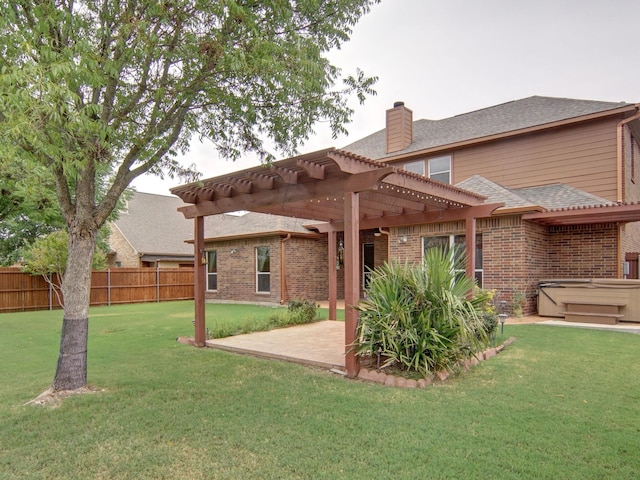 rear view of property with a pergola, a yard, and a patio area