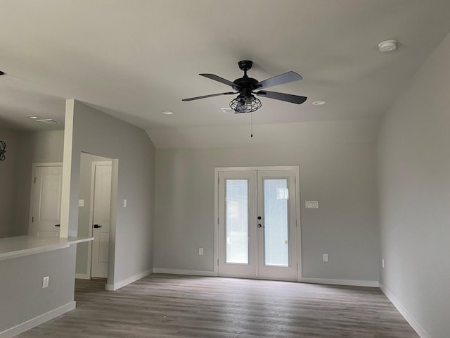 unfurnished room with light wood-type flooring, vaulted ceiling, ceiling fan, and french doors