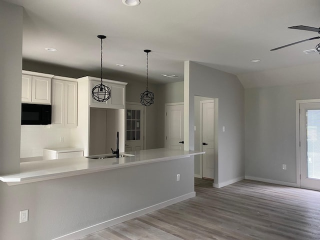 kitchen featuring hanging light fixtures, ceiling fan, sink, white cabinetry, and light hardwood / wood-style floors