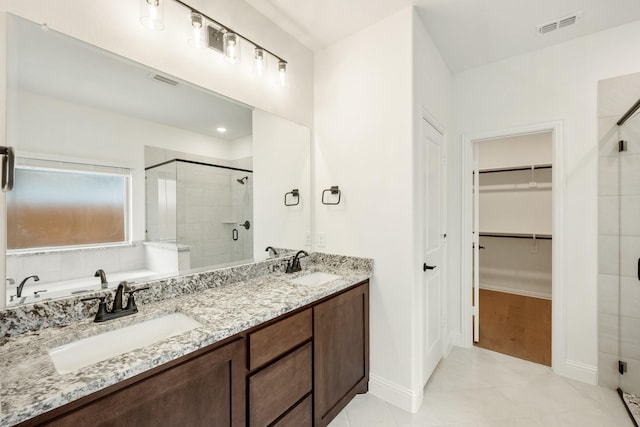 bathroom with tile patterned floors, a shower with door, and vanity