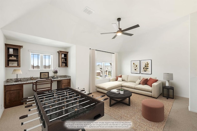 carpeted living room with built in desk and ceiling fan