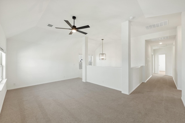 unfurnished room featuring light carpet, ceiling fan with notable chandelier, and lofted ceiling