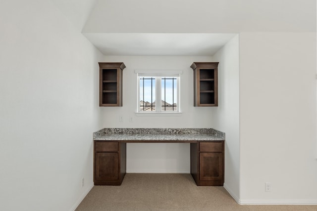 unfurnished office with light colored carpet and built in desk