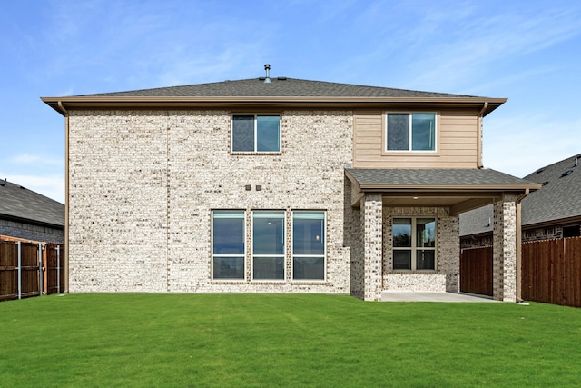 back of house featuring a lawn and a patio area