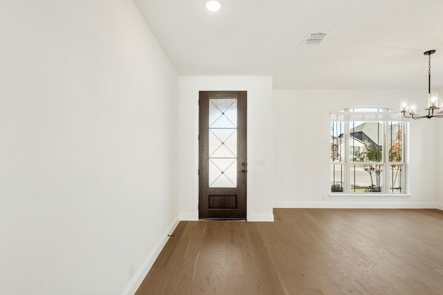 foyer entrance with hardwood / wood-style flooring and an inviting chandelier