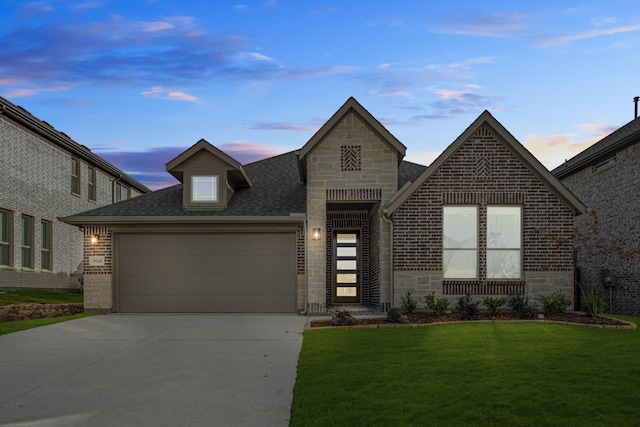 view of front facade with a yard and a garage