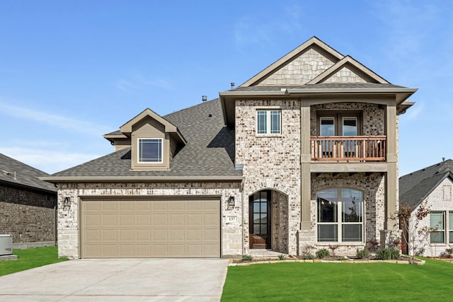 view of front of property with a balcony, a front lawn, and a garage