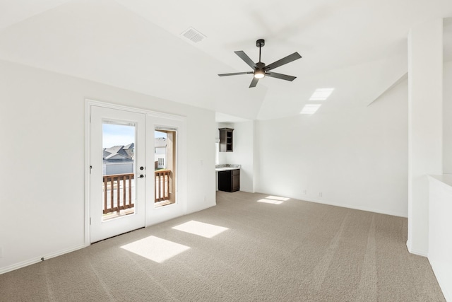 unfurnished living room featuring ceiling fan, french doors, carpet, and lofted ceiling