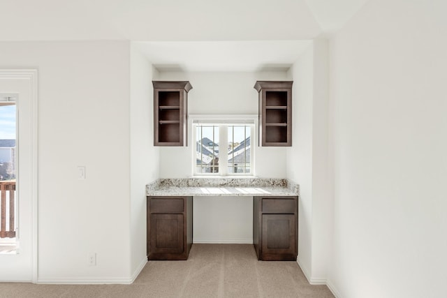 bar featuring plenty of natural light, built in desk, and light carpet