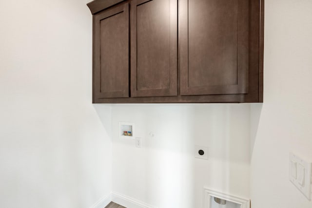 laundry area with electric dryer hookup, hookup for a washing machine, and cabinets