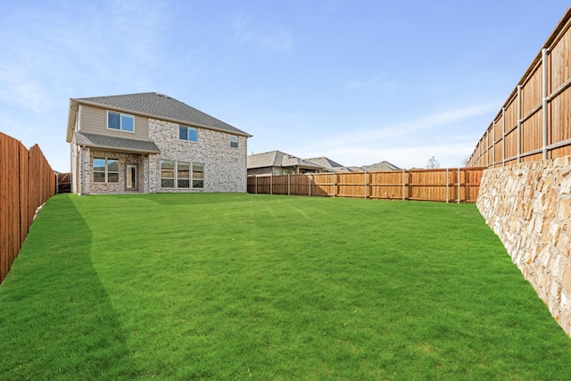 rear view of house featuring a yard