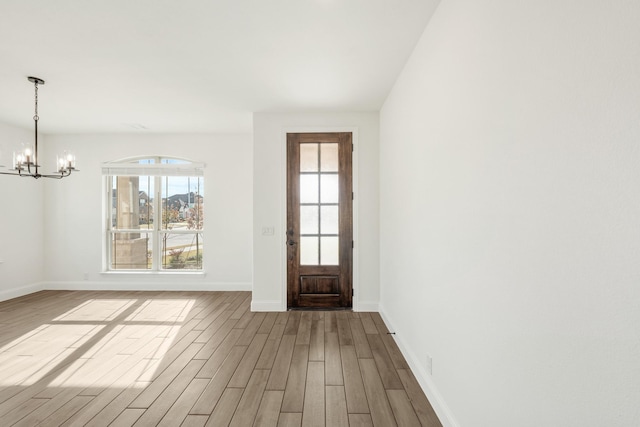 entrance foyer featuring hardwood / wood-style flooring and a notable chandelier