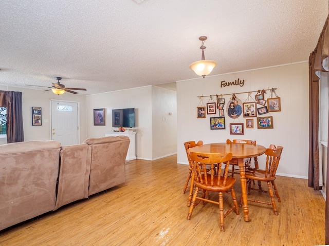 dining area with light wood-type flooring, a textured ceiling, and ceiling fan